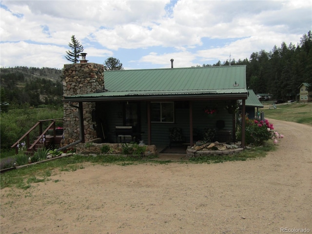 57920 US Highway 285 Unit 10, Bailey, CO 80421 - view of front facade with covered porch, a chimney, and a metal roof