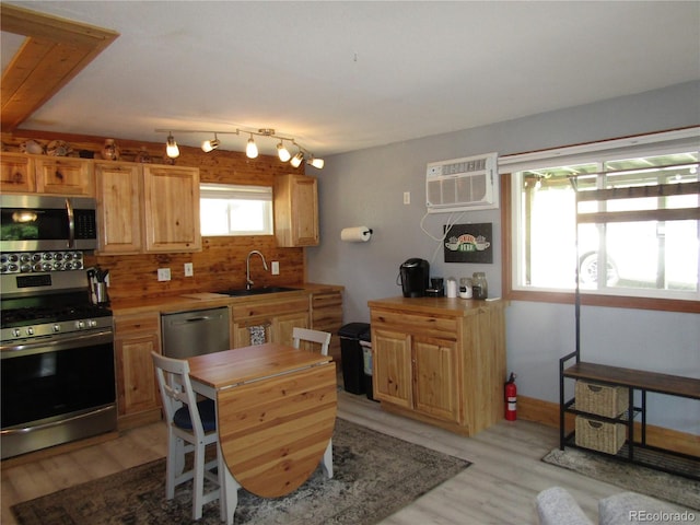 57920 US Highway 285 Unit 10, Bailey, CO 80421 - kitchen with stainless steel appliances, a wall mounted air conditioner, decorative backsplash, light wood-style flooring, and wooden counters