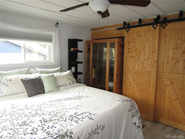 57920 US Highway 285 Unit 10, Bailey, CO 80421 - bedroom with light wood-style floors, a barn door, and ceiling fan
