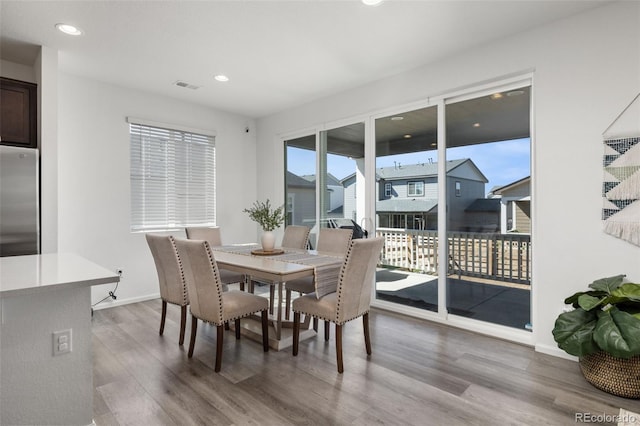 dining space with light wood-style floors, baseboards, visible vents, and recessed lighting