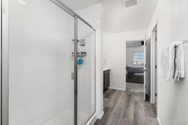 full bath with visible vents, a stall shower, connected bathroom, vanity, and wood finished floors