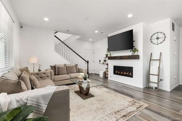 living room featuring stairs, recessed lighting, visible vents, and wood finished floors