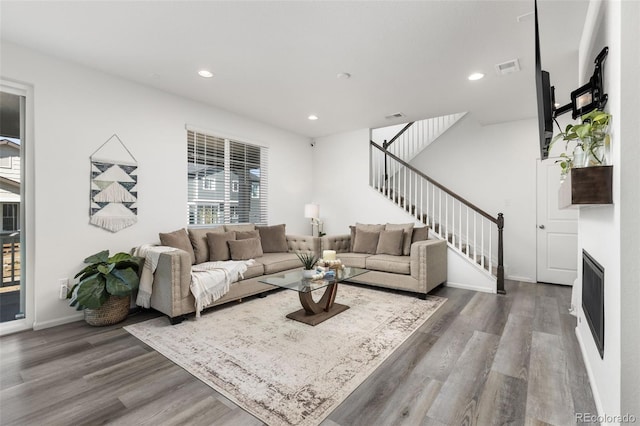 living area featuring stairs, baseboards, wood finished floors, and recessed lighting