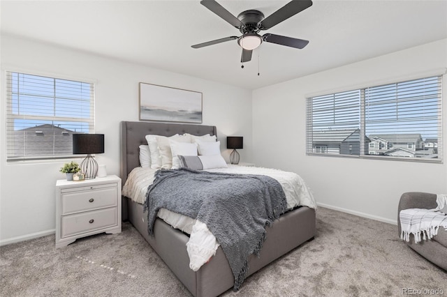 bedroom featuring a ceiling fan, light colored carpet, and baseboards