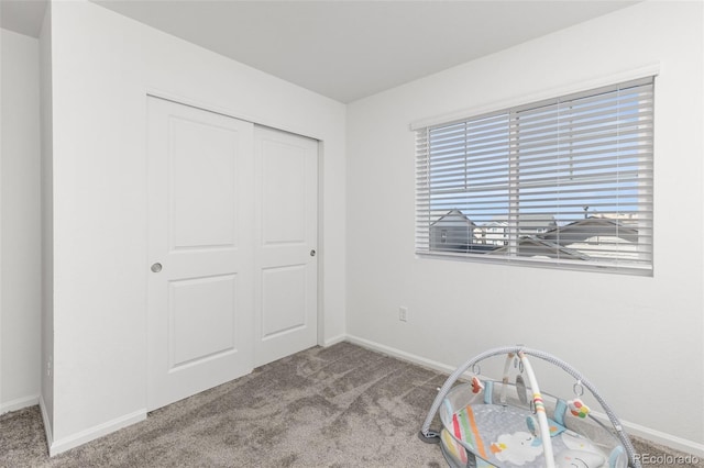 interior space with a closet, carpet, and baseboards