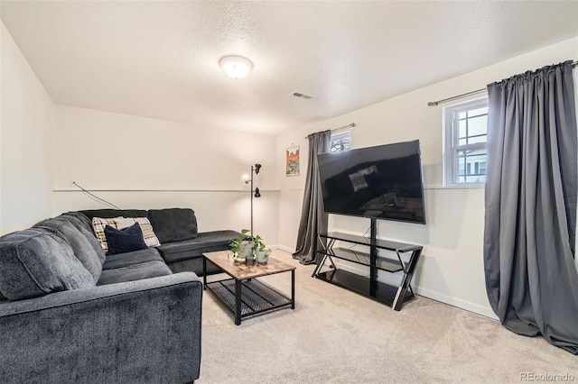 living area featuring carpet floors, visible vents, a textured ceiling, and baseboards