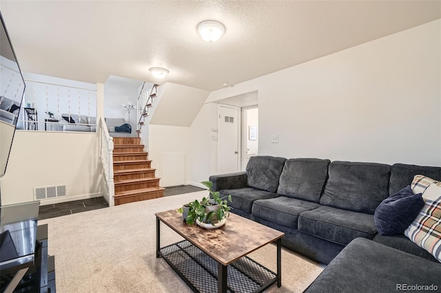 living area featuring stairs, visible vents, and a textured ceiling