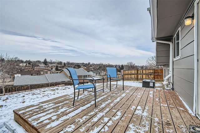 snow covered deck featuring a residential view and fence