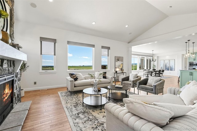 9510 Orion Way, Arvada, CO 80007 - living room featuring a glass covered fireplace, a chandelier, light wood finished floors, recessed lighting, and baseboards