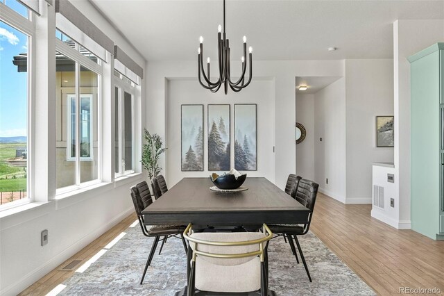 9510 Orion Way, Arvada, CO 80007 - dining area featuring light wood-style floors, a chandelier, and baseboards