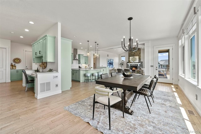 9510 Orion Way, Arvada, CO 80007 - dining room featuring recessed lighting, light wood-style flooring, a chandelier, and a stone fireplace
