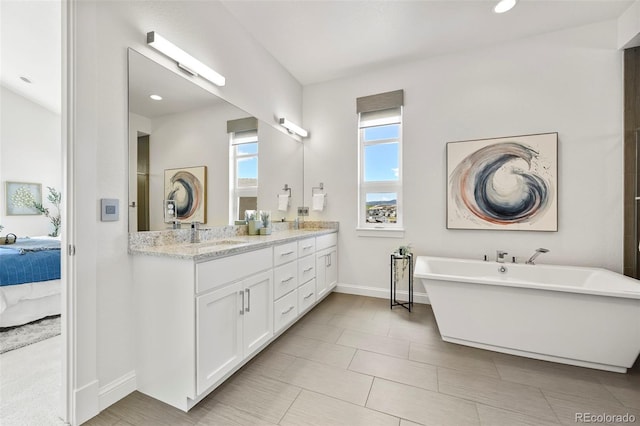 9510 Orion Way, Arvada, CO 80007 - bathroom with baseboards, ensuite bath, double vanity, and a freestanding tub