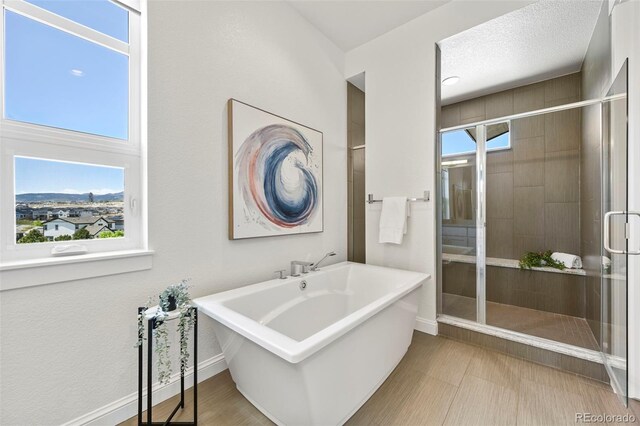 9510 Orion Way, Arvada, CO 80007 - full bathroom featuring a freestanding tub, a stall shower, and baseboards