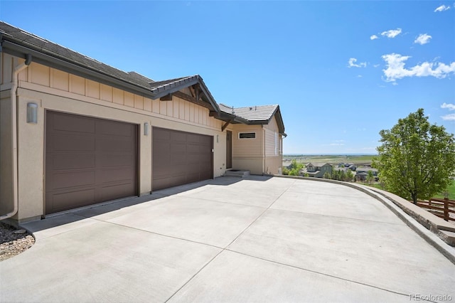 9510 Orion Way, Arvada, CO 80007 - view of home's exterior with driveway, an attached garage, and board and batten siding