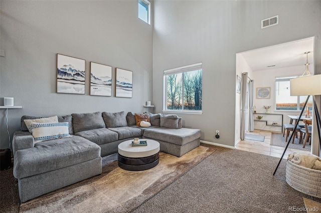 carpeted living room with a high ceiling