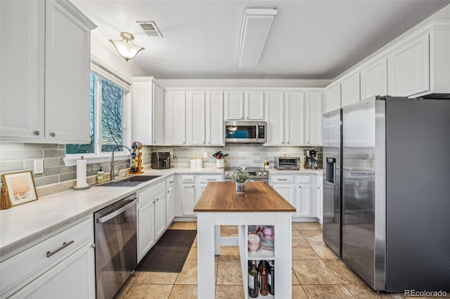 kitchen featuring white cabinets, appliances with stainless steel finishes, and sink