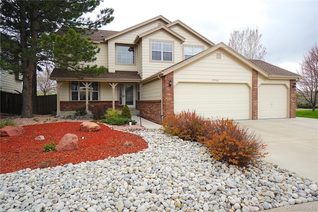 view of front of home with concrete driveway, brick siding, fence, and a garage