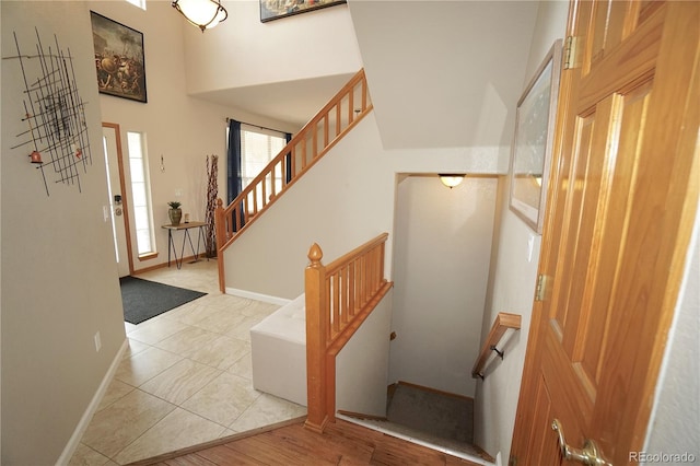 entrance foyer featuring stairway, baseboards, and a high ceiling