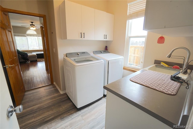 washroom featuring cabinet space, light wood-style floors, separate washer and dryer, and a sink