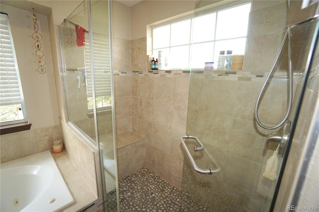 bathroom featuring a shower stall, plenty of natural light, and a whirlpool tub