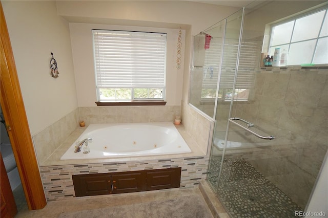 bathroom featuring a stall shower and a whirlpool tub