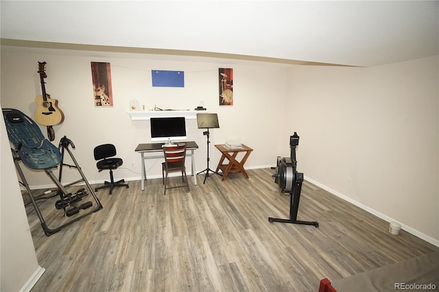 exercise room featuring baseboards and wood finished floors