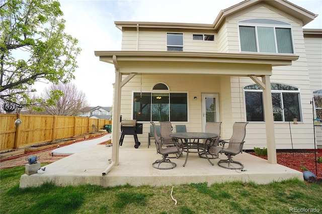 rear view of house with a fenced backyard and a patio