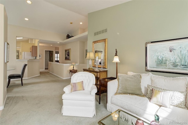 living room featuring recessed lighting, light colored carpet, visible vents, vaulted ceiling, and baseboards