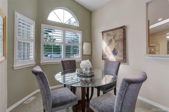 carpeted dining space with baseboards, visible vents, and a ceiling fan