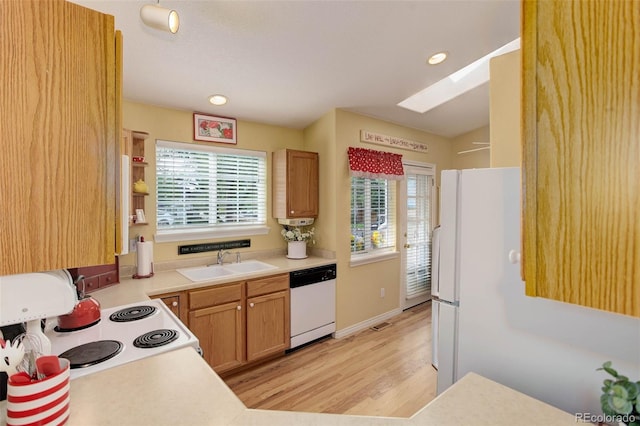 kitchen featuring light wood-style flooring, white appliances, a sink, light countertops, and brown cabinets