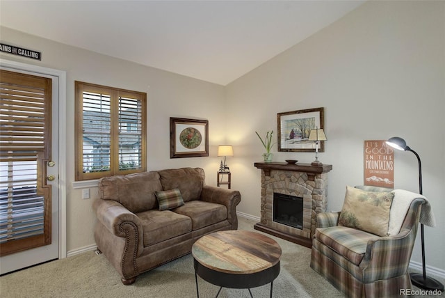 living room with lofted ceiling, carpet flooring, a stone fireplace, and baseboards