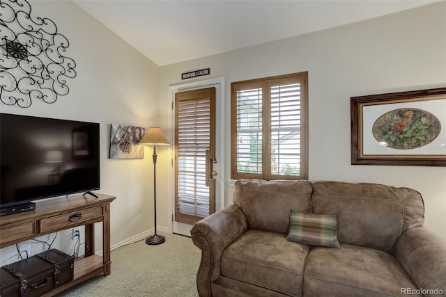 living area featuring lofted ceiling, carpet, and baseboards