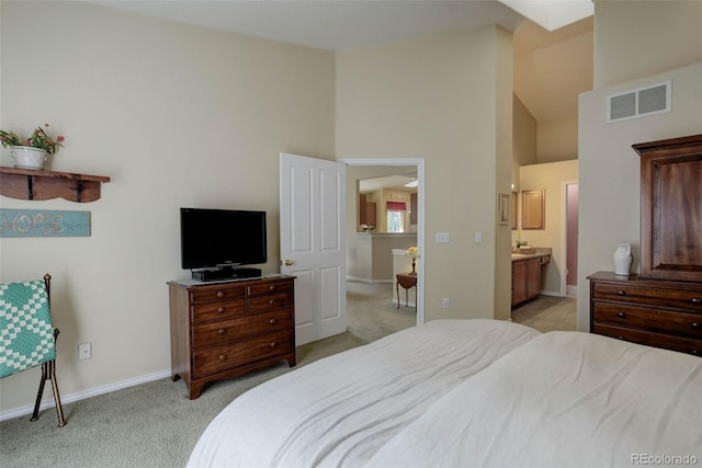 bedroom featuring visible vents, ensuite bathroom, light carpet, high vaulted ceiling, and baseboards