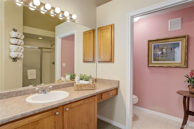 bathroom featuring visible vents, toilet, a stall shower, vanity, and baseboards