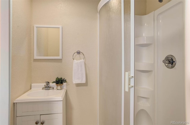 bathroom with walk in shower and vanity