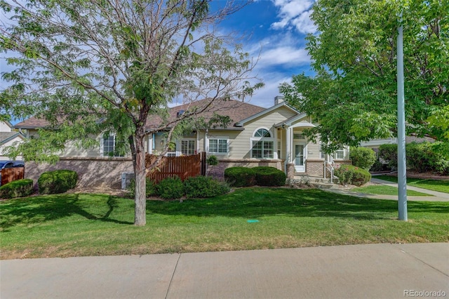 view of front of property with a front yard, fence, and brick siding