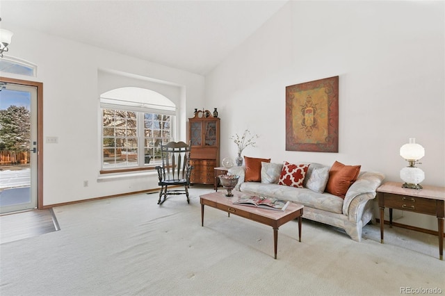 carpeted living room featuring high vaulted ceiling