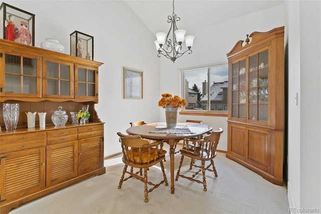 carpeted dining area featuring lofted ceiling and a chandelier