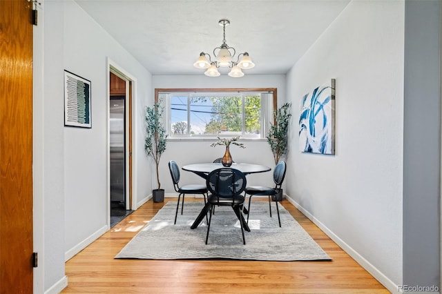 5920 Garrison St, Arvada, CO 80004 - dining room featuring a chandelier, light wood-type flooring, and baseboards