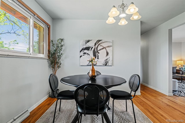 5920 Garrison St, Arvada, CO 80004 - dining area with baseboard heating, a chandelier, wood finished floors, and baseboards