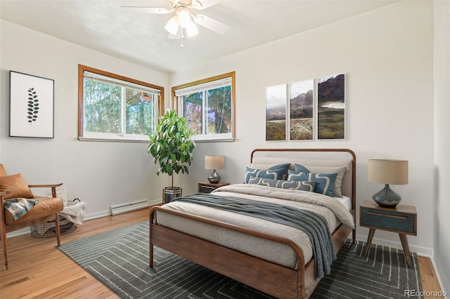 5920 Garrison St, Arvada, CO 80004 - bedroom featuring baseboard heating, wood finished floors, baseboards, and a ceiling fan