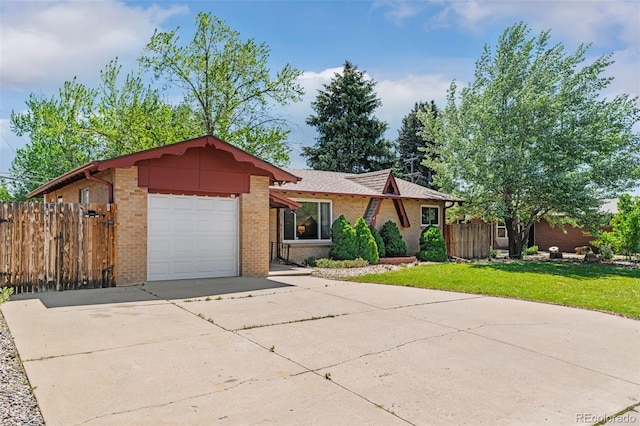 5920 Garrison St, Arvada, CO 80004 - view of front of property featuring brick siding, an attached garage, and concrete driveway