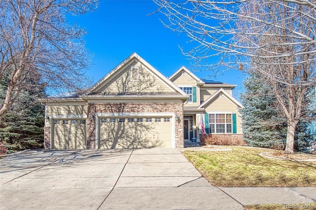 traditional-style house featuring a garage, driveway, and a front yard