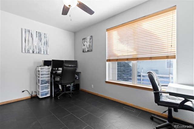 office space with visible vents, a ceiling fan, and baseboards