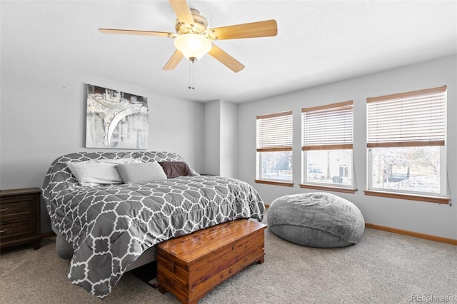 carpeted bedroom with ceiling fan and baseboards