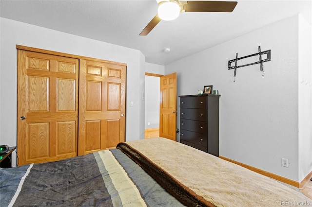 bedroom featuring a ceiling fan, a closet, and baseboards