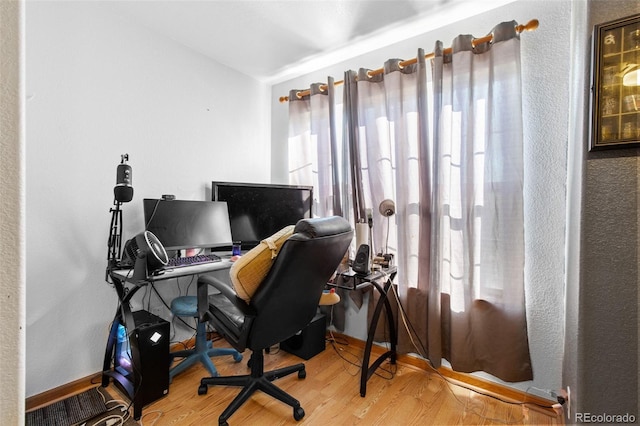 office area featuring vaulted ceiling, wood finished floors, and baseboards