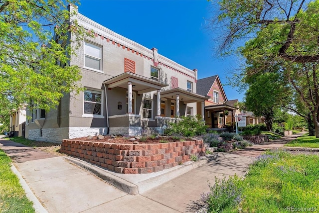 2566 N Emerson St, Denver, CO 80205 - view of front of home featuring brick siding and a porch