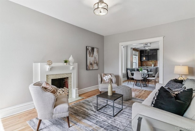 2566 N Emerson St, Denver, CO 80205 - living area with wood finished floors, baseboards, and a brick fireplace