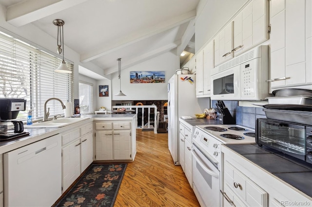 kitchen with white appliances, a sink, light wood-style floors, hanging light fixtures, and white cabinetry